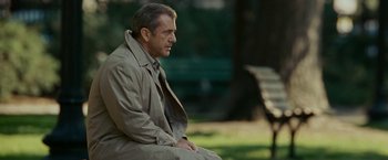 Movie still from “Edge of Darkness” (2010), directed by Martin Campbell – A man sitting on top of a bench in a park; Medium shot, Over the shoulder angle