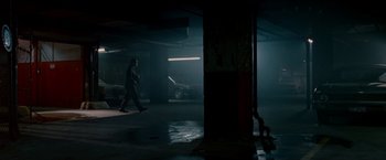Movie still from “Edge of Darkness” (2010), directed by Martin Campbell – A man walking in a parking garage at night; Extreme Wide shot, Low angle