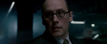 Movie still from “Edge of Darkness” (2010), directed by Martin Campbell – A man wearing a suit and glasses; Close Up shot, Low angle