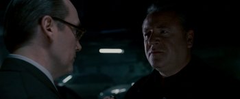 Movie still from “Edge of Darkness” (2010), directed by Martin Campbell – Two men are talking in a dark room; Close Up shot, Over the shoulder angle