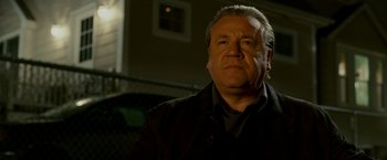 Movie still from “Edge of Darkness” (2010), directed by Martin Campbell – An older man in a black shirt and black jacket; Close Up shot, Low angle