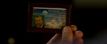 Movie still from “Edge of Darkness” (2010), directed by Martin Campbell – A person is holding up a washington drivers license; Extreme Close Up shot, Overhead angle