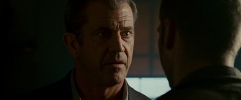 Movie still from “Edge of Darkness” (2010), directed by Martin Campbell – An older man with a serious look on his face; Close Up shot, Over the shoulder angle