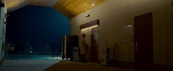 Movie still from “Edge of Darkness” (2010), directed by Martin Campbell – A man standing in front of a building at night; Extreme Wide shot, Low angle