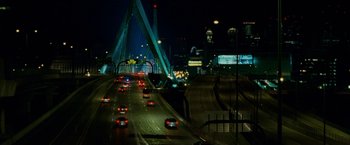 Movie still from “Edge of Darkness” (2010), directed by Martin Campbell – Cars are driving on a highway at night; Extreme Wide shot, High angle