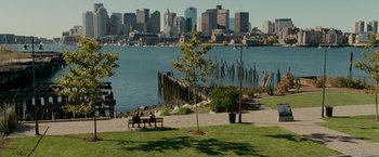 Movie still from “Edge of Darkness” (2010), directed by Martin Campbell – Two people sitting on a bench near a body of water; Extreme Wide shot, High angle