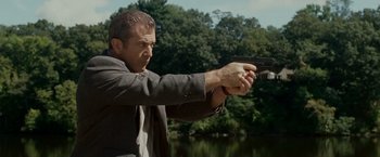 Movie still from “Edge of Darkness” (2010), directed by Martin Campbell – A man holding a gun in his hand; Medium shot, Low angle
