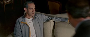 Movie still from “Edge of Darkness” (2010), directed by Martin Campbell – A man sitting on top of a couch in front of a window; Medium shot, High angle