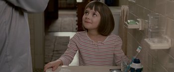 Movie still from “Edge of Darkness” (2010), directed by Martin Campbell – A young girl sitting at a table looking up; Close Up shot, Over the shoulder angle