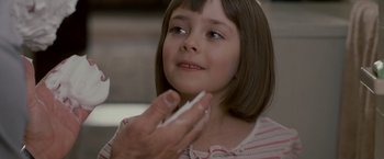Movie still from “Edge of Darkness” (2010), directed by Martin Campbell – A little girl holding a cell phone up to her face; Close Up shot, Over the shoulder angle