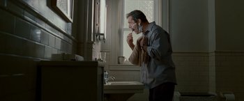 Movie still from “Edge of Darkness” (2010), directed by Martin Campbell – A man brushing his teeth in a bathroom; Medium shot, Low angle