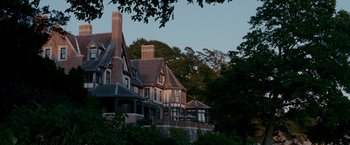 Movie still from “Edge of Darkness” (2010), directed by Martin Campbell – A large house with a large porch on top of it; Extreme Wide shot, Low angle