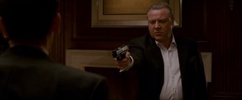 Movie still from “Edge of Darkness” (2010), directed by Martin Campbell – A man in a suit and tie holding a gun; Medium shot, Low angle