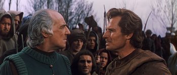 Movie still from “El Cid” (1961), directed by Anthony Mann – A group of men standing next to each other in a field; Close Up shot, Over the shoulder angle