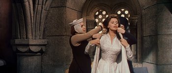 Movie still from “El Cid” (1961), directed by Anthony Mann – A woman is helping another woman put on a wedding dress; Medium shot, Low angle