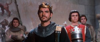 Movie still from “El Cid” (1961), directed by Anthony Mann – A man wearing a gold crown and a black robe; Close Up shot, Low angle