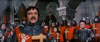 Movie still from “El Cid” (1961), directed by Anthony Mann – A group of men in red and black uniforms in front of a wall; Medium shot, Low angle