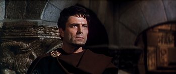 Movie still from “El Cid” (1961), directed by Anthony Mann – A person wearing a suit and tie; Close Up shot, Low angle