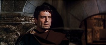 Movie still from “El Cid” (1961), directed by Anthony Mann – A person wearing a suit and tie; Close Up shot, Low angle