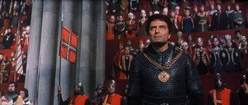 Movie still from “El Cid” (1961), directed by Anthony Mann – A man in a chain mail outfit standing in front of a crowd of people; Medium shot, Low angle