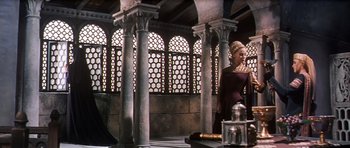 Movie still from “El Cid” (1961), directed by Anthony Mann – A woman standing in front of a building with pillars; Wide shot, Low angle