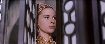 Movie still from “El Cid” (1961), directed by Anthony Mann – A woman in a gold dress looking out a window; Close Up shot, Low angle