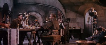 Movie still from “El Cid” (1961), directed by Anthony Mann – A man and a woman sitting at a dining table; Wide shot, High angle