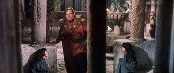 Movie still from “El Cid” (1961), directed by Anthony Mann – A man dressed as a roman emperor and a child dressed as an angel; Medium shot, Over the shoulder angle