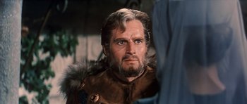 Movie still from “El Cid” (1961), directed by Anthony Mann – A man with a beard and a fur trimmed jacket; Close Up shot, Over the shoulder angle