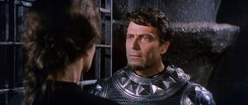 Movie still from “El Cid” (1961), directed by Anthony Mann – A man in a suit of armor looking into a mirror; Close Up shot, Over the shoulder angle