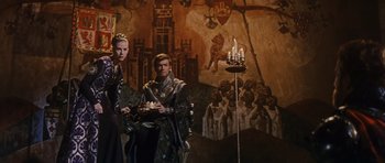Movie still from “El Cid” (1961), directed by Anthony Mann – A man and a woman standing in front of a painting; Wide shot, Low angle