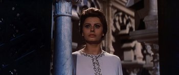 Movie still from “El Cid” (1961), directed by Anthony Mann – A woman standing next to a pillar wearing a white dress; Close Up shot, Low angle