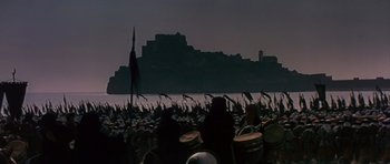 Movie still from “El Cid” (1961), directed by Anthony Mann – A crowd of people standing in front of a large body of water; Extreme Wide shot, High angle