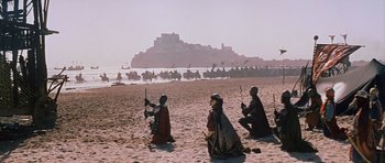 Movie still from “El Cid” (1961), directed by Anthony Mann – A group of people sitting on top of a sandy beach; Extreme Wide shot, Low angle