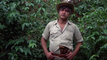 Movie still from “El Norte” (1983), directed by Gregory Nava – A man wearing a hat standing in front of a bush; Medium shot, Low angle
