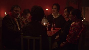Movie still from “El Norte” (1983), directed by Gregory Nava – A group of people sitting at a table with drinks; Medium shot, Over the shoulder angle