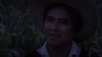 Movie still from “El Norte” (1983), directed by Gregory Nava – A man wearing a straw hat in the dark; Close Up shot, Over the shoulder angle