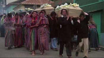 Movie still from “El Norte” (1983), directed by Gregory Nava – A group of people walking down a street carrying baskets of flowers; Wide shot, Low angle