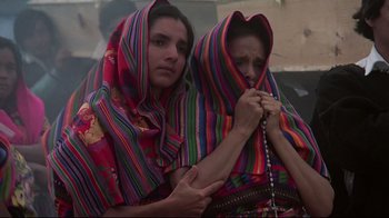 Movie still from “El Norte” (1983), directed by Gregory Nava – Two women wrapped in colorful blankets holding hands; Medium shot, Low angle