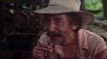 Movie still from “El Norte” (1983), directed by Gregory Nava – An older man wearing a straw hat is sitting down; Close Up shot, Low angle