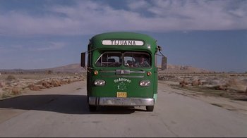 Movie still from “El Norte” (1983), directed by Gregory Nava – A bus driving down a road near a mountain; Extreme Wide shot, Low angle