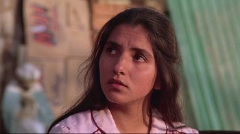 Movie still from “El Norte” (1983), directed by Gregory Nava – A young woman with long dark brown hair looking to her left; Close Up shot, Low angle