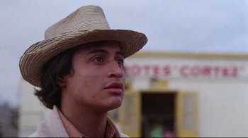 Movie still from “El Norte” (1983), directed by Gregory Nava – A man wearing a straw hat looking to his left; Close Up shot, Low angle