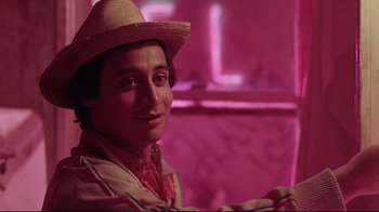 Movie still from “El Norte” (1983), directed by Gregory Nava – A man wearing a straw hat in a pink room; Close Up shot, Low angle