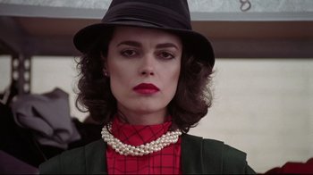 Movie still from “El Norte” (1983), directed by Gregory Nava – A woman wearing a black hat and a red shirt; Close Up shot, Low angle