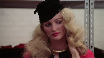 Movie still from “El Norte” (1983), directed by Gregory Nava – A woman wearing a black hat and a gold necklace; Close Up shot, Over the shoulder angle