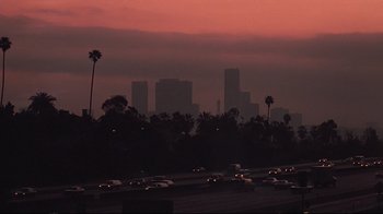 Movie still from “El Norte” (1983), directed by Gregory Nava – Cars are driving down a freeway at dusk; Extreme Wide shot, High angle