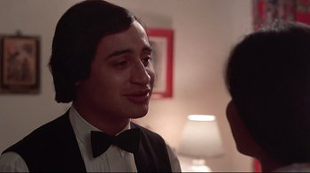 Movie still from “El Norte” (1983), directed by Gregory Nava – A young man in a tuxedo talking to another young man; Close Up shot, Over the shoulder angle