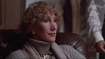 Movie still from “El Norte” (1983), directed by Gregory Nava – An older woman sitting in a chair wearing a sweater; Close Up shot, High angle