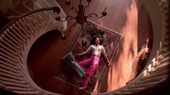 Movie still from “El Norte” (1983), directed by Gregory Nava – A woman laying on the floor with a vacuum cleaner; Wide shot, Overhead angle